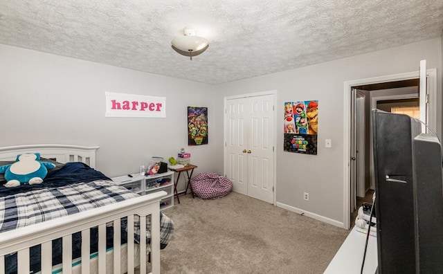 carpeted bedroom featuring a textured ceiling and a closet