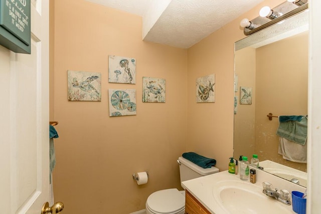 bathroom featuring vanity, a textured ceiling, and toilet