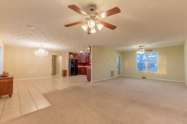 unfurnished living room featuring ceiling fan with notable chandelier and light tile patterned floors