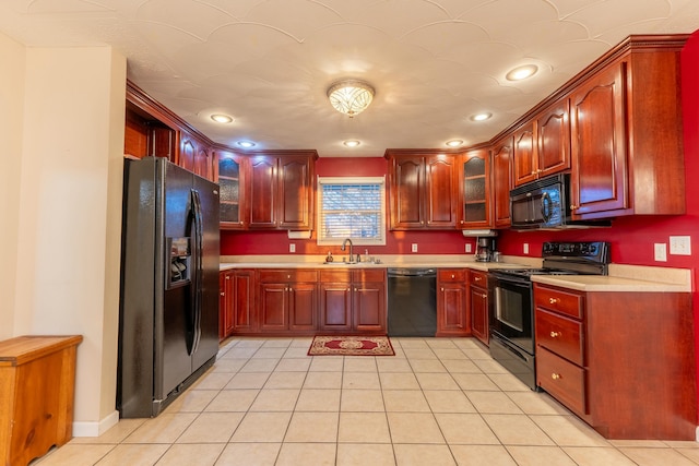 kitchen with sink, light tile patterned floors, and black appliances