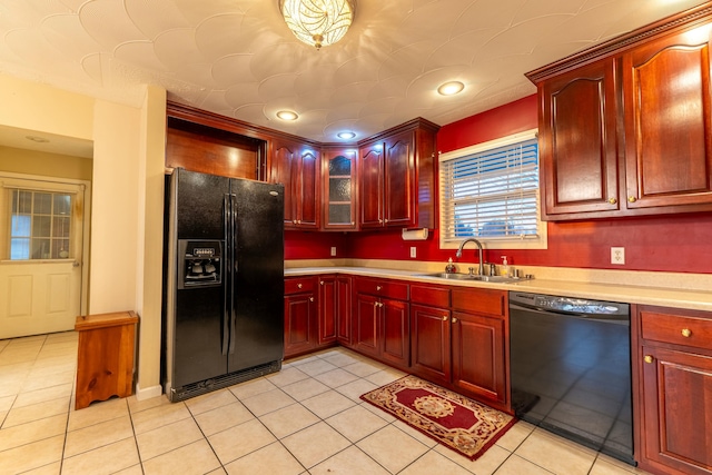 kitchen featuring sink, light tile patterned floors, and black appliances