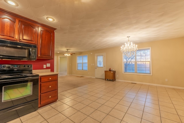 kitchen with hanging light fixtures, ceiling fan with notable chandelier, black appliances, and light tile patterned floors