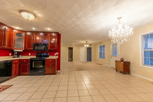 kitchen featuring pendant lighting, ceiling fan with notable chandelier, light tile patterned floors, and black appliances