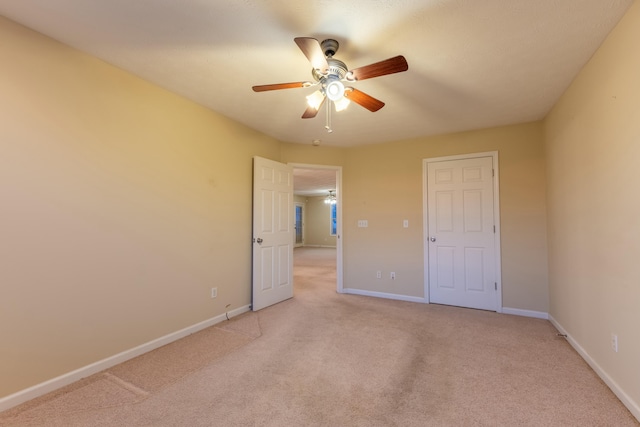 unfurnished bedroom featuring light carpet and ceiling fan