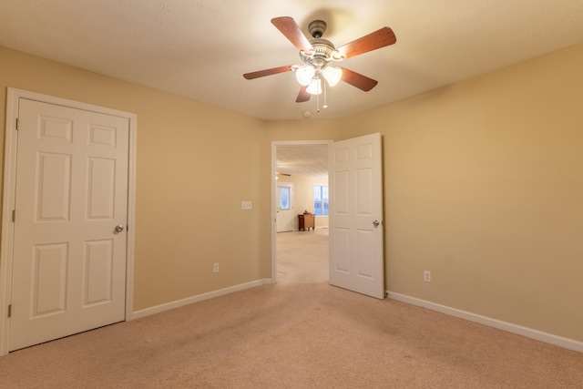 unfurnished bedroom with ceiling fan and light carpet