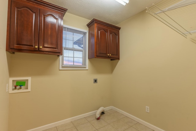 washroom with cabinets, light tile patterned floors, hookup for a washing machine, hookup for an electric dryer, and a textured ceiling