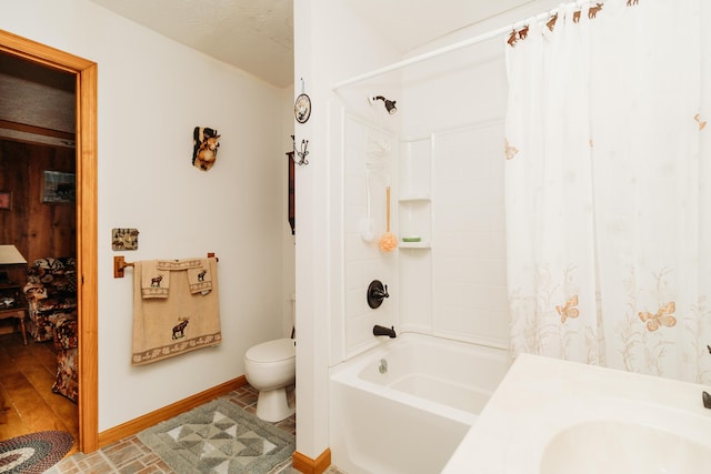 full bathroom featuring sink, shower / bath combination with curtain, a textured ceiling, and toilet