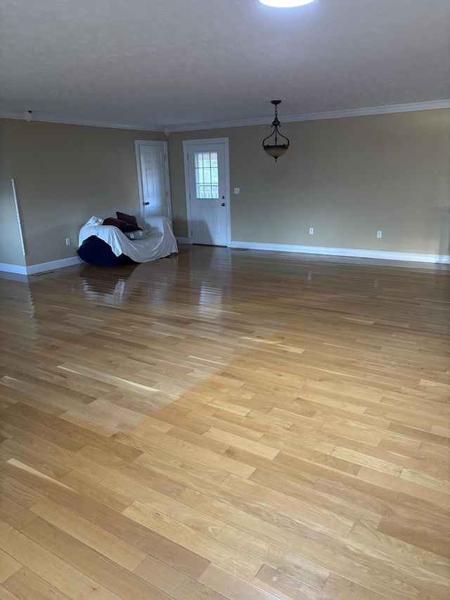 interior space featuring ornamental molding and light wood-type flooring