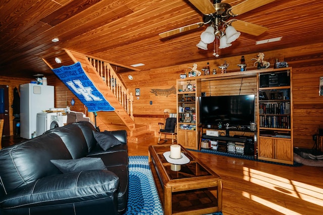 living room with wood ceiling, wooden walls, separate washer and dryer, and hardwood / wood-style floors