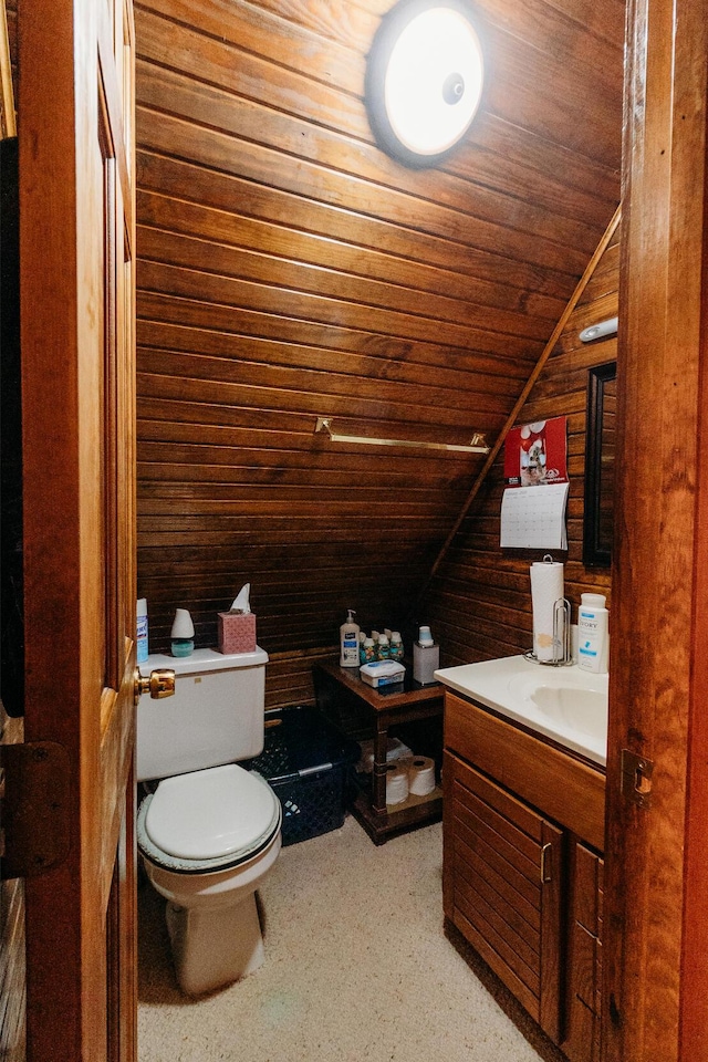 bathroom featuring wood ceiling, wooden walls, vanity, vaulted ceiling, and toilet