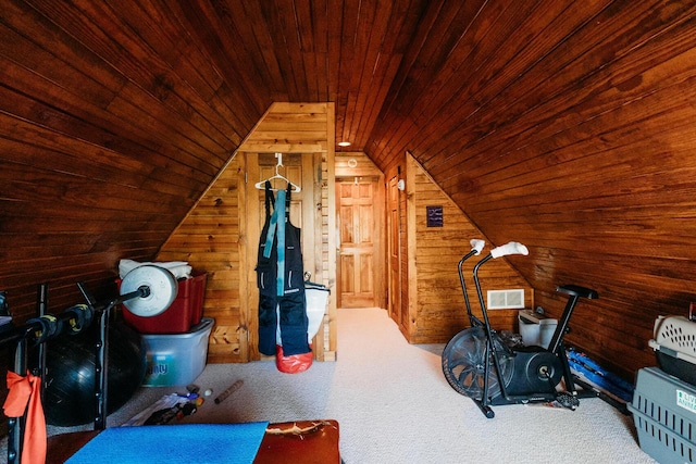 exercise room with wood ceiling, vaulted ceiling, carpet, and wood walls