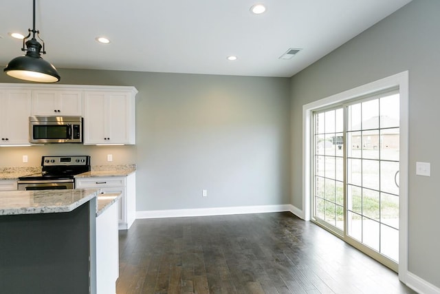 kitchen with decorative light fixtures, white cabinets, stainless steel appliances, light stone countertops, and dark wood-type flooring