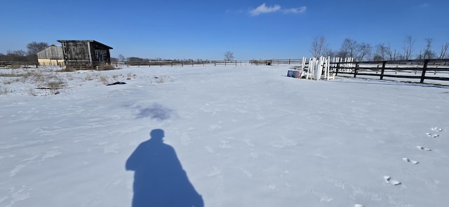 snowy yard with a rural view