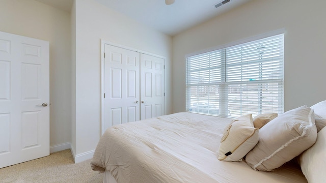 bedroom featuring light colored carpet and a closet