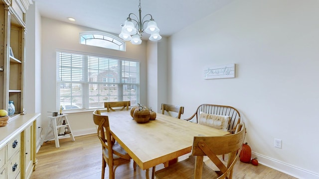 dining space with a chandelier and light hardwood / wood-style flooring