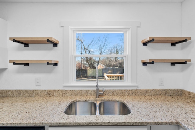 kitchen featuring sink and light stone countertops