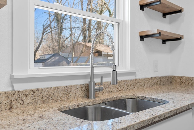 room details featuring light stone countertops and sink