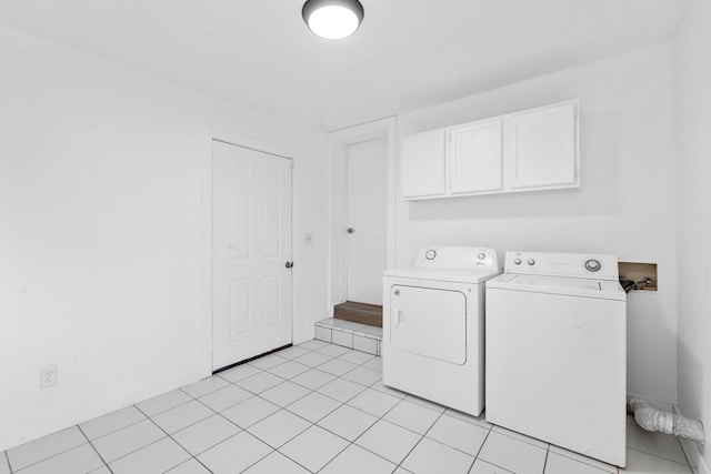 laundry room featuring washer and dryer, light tile patterned floors, and cabinets