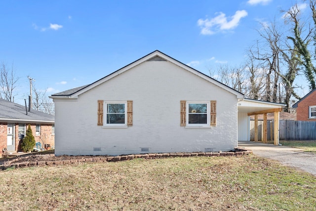 view of property exterior featuring a carport and a yard