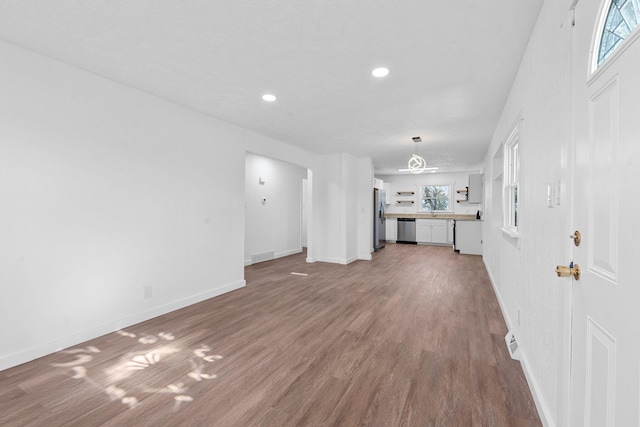 unfurnished living room featuring hardwood / wood-style flooring and sink