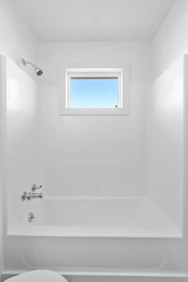 bathroom featuring bathtub / shower combination and toilet