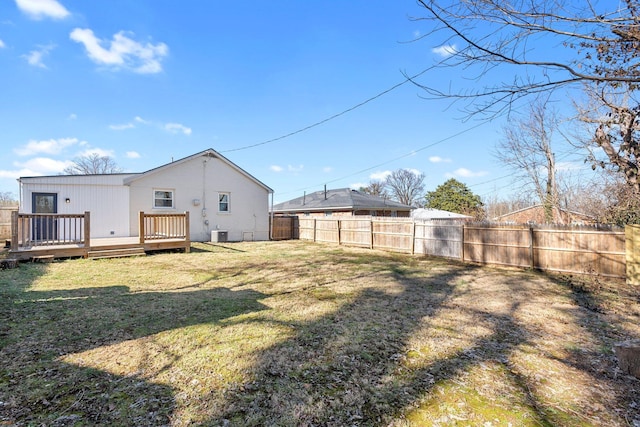 rear view of property featuring central AC unit, a yard, and a deck