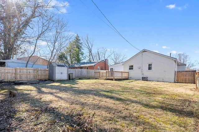 view of yard with a storage shed, a deck, and central air condition unit