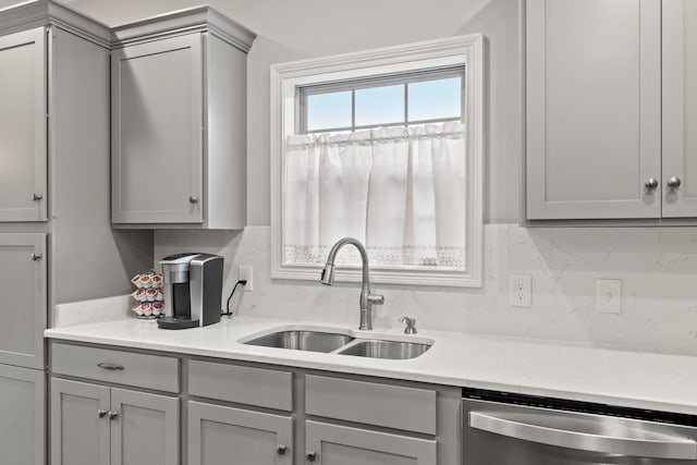 kitchen with decorative backsplash, dishwasher, light countertops, gray cabinetry, and a sink