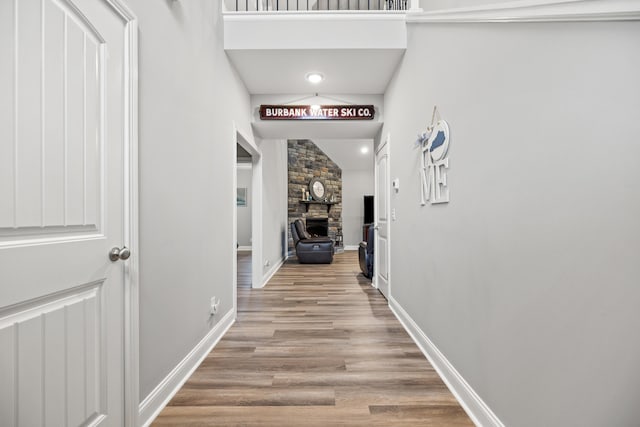 corridor with baseboards and light wood finished floors