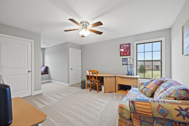 office space featuring a ceiling fan, light carpet, and baseboards