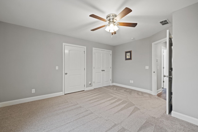 unfurnished bedroom featuring light colored carpet, visible vents, and baseboards