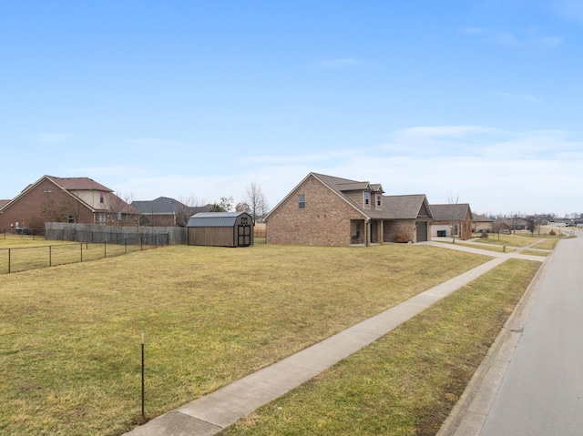 view of yard with a storage shed, an outbuilding, and fence private yard