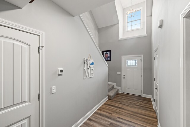 entryway with dark wood-style flooring, a healthy amount of sunlight, stairway, and baseboards