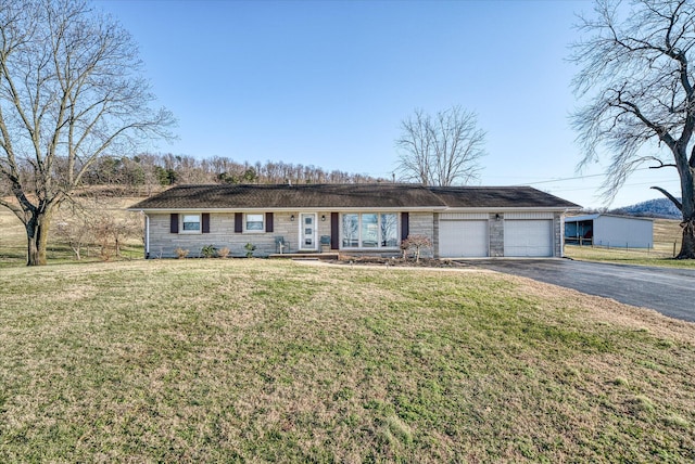 single story home featuring a garage and a front lawn