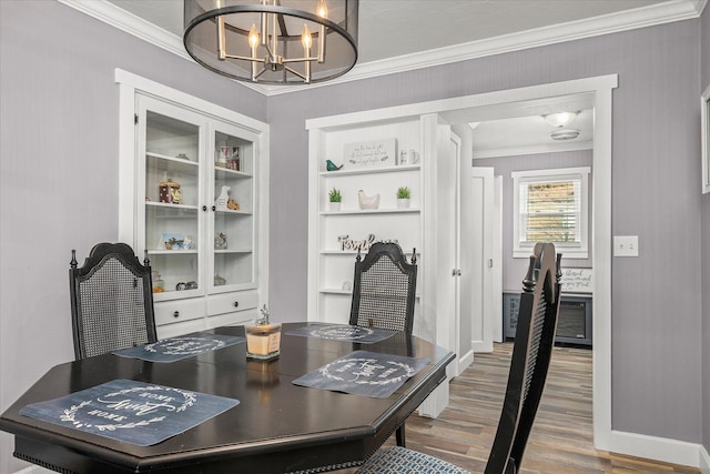 dining space with an inviting chandelier, wood-type flooring, and ornamental molding