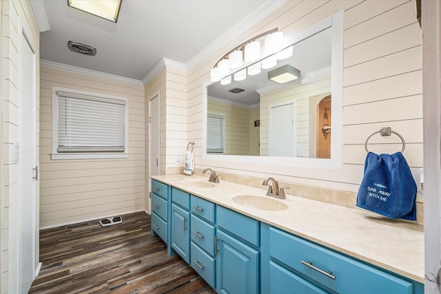 bathroom with crown molding, wood-type flooring, vanity, and wooden walls