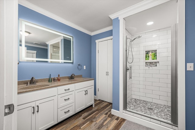 bathroom with vanity, hardwood / wood-style floors, ornamental molding, and tiled shower