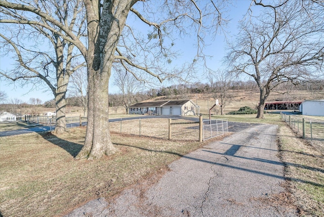view of front of property featuring an outdoor structure, a front lawn, and a rural view
