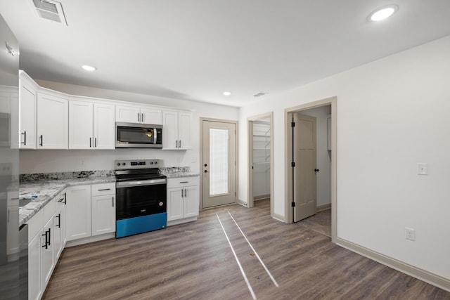 kitchen with stainless steel appliances, dark hardwood / wood-style flooring, light stone countertops, and white cabinets