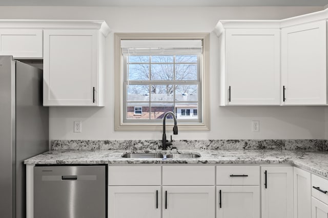 kitchen featuring white cabinetry, appliances with stainless steel finishes, light stone countertops, and sink