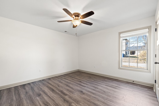 spare room featuring dark wood-type flooring and ceiling fan