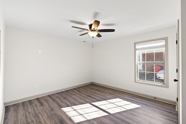 empty room featuring dark wood-type flooring and ceiling fan