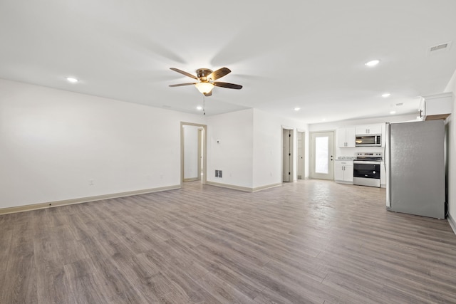 unfurnished living room featuring ceiling fan and light hardwood / wood-style floors