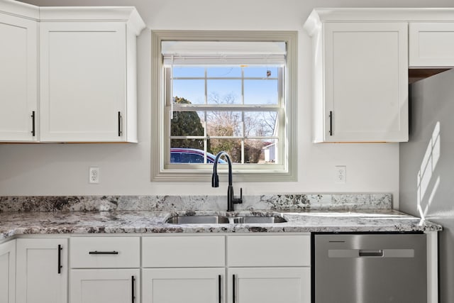 kitchen featuring stainless steel appliances, light stone countertops, sink, and white cabinets