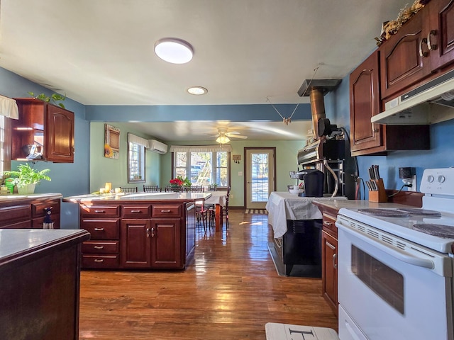 kitchen with ceiling fan, dark hardwood / wood-style floors, white electric range oven, and a wall unit AC