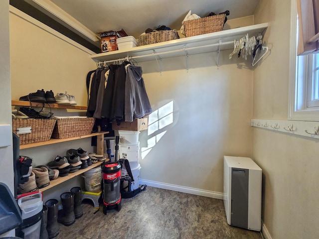 walk in closet with dark wood-type flooring