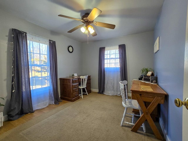 home office featuring light carpet and ceiling fan