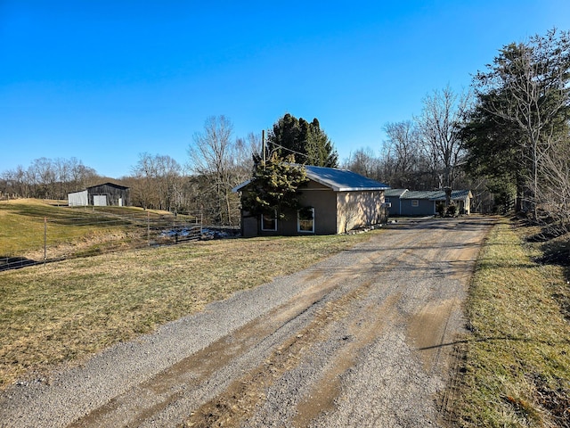 view of front of property featuring a rural view and a front lawn