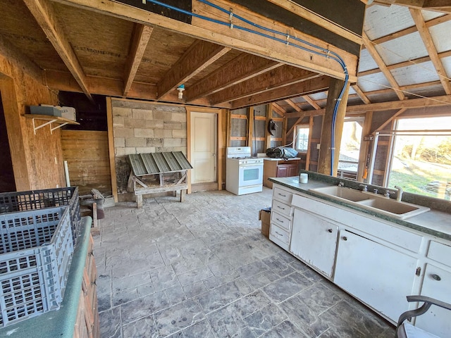 interior space featuring sink, white gas stove, and white cabinets