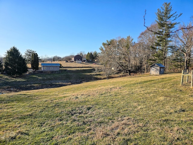 view of yard with a storage shed and a rural view